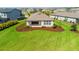 Well-maintained backyard featuring lush green grass and landscaping with mulch and colorful plants at 9292 Tequila Sunrise Dr, Sarasota, FL 34241