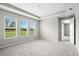 Bright bedroom with carpet, neutral walls, and windows overlooking a green lawn at 9292 Tequila Sunrise Dr, Sarasota, FL 34241