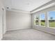 Spacious primary bedroom with neutral walls, plush carpet, trey ceiling and views from three large windows at 9292 Tequila Sunrise Dr, Sarasota, FL 34241