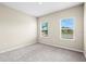 Bedroom with two windows offering bright natural light and neutral-toned walls with modern carpet at 9292 Tequila Sunrise Dr, Sarasota, FL 34241