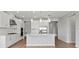 Modern kitchen with white cabinetry, stainless steel appliances, a large island and pendant lighting at 9292 Tequila Sunrise Dr, Sarasota, FL 34241