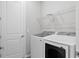 Functional laundry room equipped with modern washer and dryer units and overhead shelving at 9292 Tequila Sunrise Dr, Sarasota, FL 34241