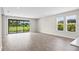 Large living room with wood-look floors and a sliding glass door showcasing beautiful views of the backyard at 9292 Tequila Sunrise Dr, Sarasota, FL 34241