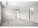 Spacious primary bedroom featuring soft carpet, tray ceiling, and doors to the bathroom and walk-in closet at 9292 Tequila Sunrise Dr, Sarasota, FL 34241