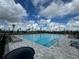Community pool with lounge chairs on deck. Clear blue sky at 9292 Tequila Sunrise Dr, Sarasota, FL 34241