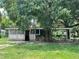 Charming single-story home featuring mature trees and a screened-in porch for outdoor enjoyment at 9344 Peony St, New Port Richey, FL 34654