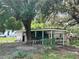 Cozy single-story house with carport nestled amongst mature trees, blending comfort and nature at 9344 Peony St, New Port Richey, FL 34654