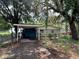 Quaint home with a carport and mature trees, offering a peaceful and shady outdoor space at 9344 Peony St, New Port Richey, FL 34654