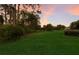 Lush backyard featuring verdant lawn and mature trees offers privacy and a natural setting for outdoor enjoyment at 10022 Laurel Valley Avenue Cir, Bradenton, FL 34202
