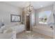 Bright bathroom featuring double sinks, tiled walk-in shower, and soaking tub at 10022 Laurel Valley Avenue Cir, Bradenton, FL 34202