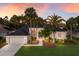 Stunning home exterior with lush landscaping, palm trees, and a two-car garage at sunset at 10022 Laurel Valley Avenue Cir, Bradenton, FL 34202