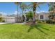 Beautiful single-story home featuring a lush green lawn and attractive landscaping with mature palm trees at 10022 Laurel Valley Avenue Cir, Bradenton, FL 34202