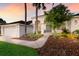 Inviting entrance to a charming home with meticulous landscaping, swaying palms, and a well-maintained two-car garage at 10022 Laurel Valley Avenue Cir, Bradenton, FL 34202