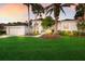 Well-manicured lawn and landscaping enhance this home's curb appeal with lush green grass and mature palm trees at 10022 Laurel Valley Avenue Cir, Bradenton, FL 34202