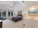 Serene main bedroom featuring tray ceilings, slider door to pool, and ensuite bathroom at 10022 Laurel Valley Avenue Cir, Bradenton, FL 34202