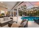 Relaxing screened lanai with cozy seating around a sparkling pool and a view of the serene wooded area at 10022 Laurel Valley Avenue Cir, Bradenton, FL 34202