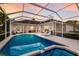 An inviting screened pool with spa and clear blue water is surrounded by a white deck and lush greenery at 10022 Laurel Valley Avenue Cir, Bradenton, FL 34202