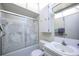 Cozy bathroom features a swan art shower door, white cabinets, and a bright skylight at 10037 62Nd N Ter # 23, St Petersburg, FL 33708