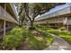 Exterior view of condo complex showcasing mature trees, pathways, plants, and exterior stairways at 10037 62Nd N Ter # 23, St Petersburg, FL 33708