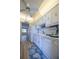 Bright kitchen with white appliances, white cabinetry and blue accent rug at 10037 62Nd N Ter # 23, St Petersburg, FL 33708