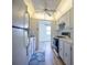 Bright kitchen with white appliances, cabinets, plank flooring, and a ceiling fan at 10037 62Nd N Ter # 23, St Petersburg, FL 33708