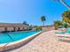Resort-style pool with brick pool deck, lounge chairs, and clubhouse in the background at 10037 62Nd N Ter # 23, St Petersburg, FL 33708