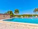 Community pool featuring beautiful blue water, pool furniture, and tropical landscaping at 10037 62Nd N Ter # 23, St Petersburg, FL 33708
