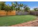 A well-maintained backyard featuring green grass, a wooden fence, and tropical landscaping at 1004 68Th Nw St, Bradenton, FL 34209