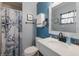 Nautical themed bathroom with a white vanity, blue accents, and ship-themed shower curtain at 1004 68Th Nw St, Bradenton, FL 34209