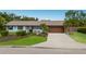 Single-story home featuring a well-kept lawn, tropical landscaping, and a spacious driveway at 1004 68Th Nw St, Bradenton, FL 34209