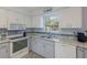 The kitchen features white cabinets and stainless steel appliances, complemented by blue tile backsplash at 1004 68Th Nw St, Bradenton, FL 34209