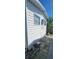 Side view of home, showcasing the exterior siding, windows, and a small space; great potential for customization at 10315 Cortez W Rd # 24-2, Bradenton, FL 34210