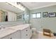 Bright bathroom with dual sinks, marble countertop, white cabinetry, and natural light at 1071 Owl Dr, Englewood, FL 34223