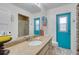 Modern bathroom featuring vibrant blue doors, granite counters, and a glass-enclosed shower at 1071 Owl Dr, Englewood, FL 34223
