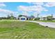 Charming single-story home featuring a well-maintained front yard and a blue garage door at 1071 Owl Dr, Englewood, FL 34223