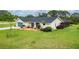 Charming single-story home with a well-manicured lawn, blue garage door, and mature landscaping at 1071 Owl Dr, Englewood, FL 34223
