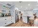 Modern kitchen features white cabinets, stainless steel appliances, and an island with seating at 1071 Owl Dr, Englewood, FL 34223
