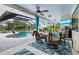 Inviting screened lanai featuring a pool, outdoor dining area, and a mounted television at 1071 Owl Dr, Englewood, FL 34223
