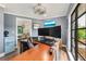 Bright office with a wood desk, two-monitor setup, and a door leading to another space at 1071 Owl Dr, Englewood, FL 34223