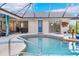 View of the pool and covered lanai area with access to different parts of the home at 1071 Owl Dr, Englewood, FL 34223