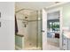 Beautifully tiled walk-in shower with glass enclosure, seamlessly flowing to outdoor living area at 1071 Owl Dr, Englewood, FL 34223