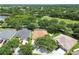 Drone image showcasing a home with an enclosed pool, positioned in a neighborhood with well-kept lawns and mature trees at 11009 Wildcat Dr, Riverview, FL 33579