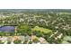An aerial view shows a lake and recreational area near a residential community with tree-lined streets at 11009 Wildcat Dr, Riverview, FL 33579