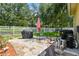 Backyard patio with a grill and patio furniture with a white picket fence and large trees at 11009 Wildcat Dr, Riverview, FL 33579
