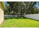 Fenced-in backyard with lush green lawn and mature trees offering shade and privacy at 11009 Wildcat Dr, Riverview, FL 33579