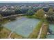Aerial view of a full-sized basketball court within the community, surrounded by lush landscaping and nearby tennis courts at 11009 Wildcat Dr, Riverview, FL 33579