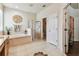 Bright bathroom with soaking tub, separate shower, and neutral tile flooring at 11009 Wildcat Dr, Riverview, FL 33579
