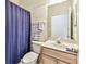 Neat bathroom featuring a vanity with traditional wood detailing and a shower with blue curtains at 11009 Wildcat Dr, Riverview, FL 33579