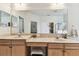 Bright bathroom with double sinks, a large mirror, and tiled countertops at 11009 Wildcat Dr, Riverview, FL 33579