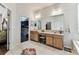Bathroom vanity with double sinks, large mirror, and access to walk-in closet at 11009 Wildcat Dr, Riverview, FL 33579